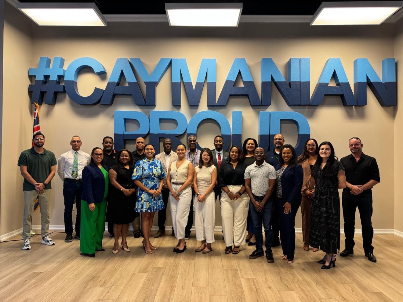 Members of the National Youth and Sports Commissions pose for a group photo at the Cayman Proud sign during the 2025–2028 onboarding meeting.